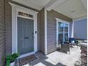 Inviting front porch with seating area and stylish front door with sidelight at 3426 Dominion Green Dr, Charlotte, NC 28269