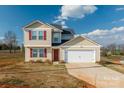 Inviting two-story home with red shutters, well-kept lawn, and attached two-car garage at 353 Webb Farm Rd, Shelby, NC 28152