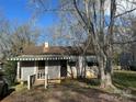 Exterior shot of a home featuring a covered porch and awning-covered windows, nestled among trees at 424 Keels Ave, Rock Hill, SC 29730