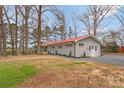 A beautiful home with painted brick, a red roof, and a gravel driveway at 4566 Fork Rd, Norwood, NC 28128