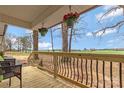 Inviting wooden front porch features decorative railings and potted flowers at 4566 Fork Rd, Norwood, NC 28128