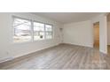 A sunlit living room featuring new floors and a large window overlooking the neighborhood at 4601 Mendham Dr, Charlotte, NC 28215