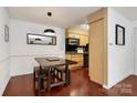 Charming dining area offers a cozy atmosphere near kitchen, complete with wood table and lighting at 4743 Hedgemore Dr # E, Charlotte, NC 28209