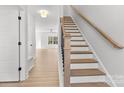 Elegant staircase featuring wood treads and a white risers, leading to the upper level with wood floors at 615 W Stanly W St, Stanfield, NC 28163