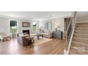 Inviting living room with a fireplace, neutral color palette, hardwood floors, and staircase access at 7024 Butternut Oak Ter, Huntersville, NC 28078