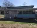 View of the home with an awning, porch with railings, and a screened in area at 143 Sunshine Trl # A32, Mount Gilead, NC 27306