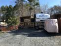 Exterior view of an RV showcasing a covered porch and gravel landscape at 156 Arrowood Trl # F26, Mount Gilead, NC 27306