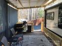 View of the RV's covered porch featuring outdoor seating, a grill, and leaf-patterned outdoor rug at 156 Arrowood Trl # F26, Mount Gilead, NC 27306