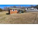 Inviting single-story brick home featuring a covered front porch and trimmed bushes at 1802 Young Dr, Conover, NC 28613