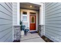 Cozy front porch with a charming red door, stone accents, and a comfortable chair at 212 Laura Elizabeth Ln, Clover, SC 29710