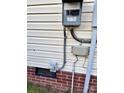 Exterior electrical box and connections on the side of the home, showcasing utilities and brick foundation at 4834 Barrett Rd, Kings Mountain, NC 28086