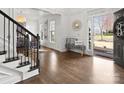 Bright foyer with wood floors, detailed trim, and staircase with black metal balusters at 604 Wisteria Walk Way, Fort Mill, SC 29715