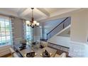 Stylish dining area with designer curtains, coffered ceilings, and elegant table setting, creating a perfect ambiance at 7020 Butternut Oak Ter, Huntersville, NC 28214