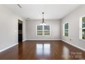 Spacious open-concept living area with hardwood floors, modern lighting, and bright windows at 887 Pointe Andrews Dr, Concord, NC 28025