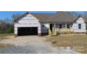 Under-construction home featuring a front porch and open garage, framed by brick base and wood columns at 122 Mason Tanner Ct # 5, Rock Hill, SC 29730