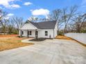 Beautiful single-story home boasting a pristine white exterior, a black roof, and a concrete driveway at 1313 Gidney St, Shelby, NC 28150