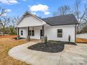 Beautiful single-story home boasting a pristine white exterior, a black roof, and a concrete driveway at 1313 Gidney St, Shelby, NC 28150