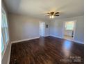 Spacious living room featuring gleaming hardwood floors, neutral paint, and a ceiling fan at 211 W Roswell St, Troy, NC 27371