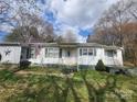 Charming one-story home with white siding, green shutters, an American flag, and a well-manicured front lawn at 316 Reese St, Gastonia, NC 28056