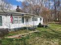 Charming one-story home with white siding, green shutters, an American flag, and a well-manicured front lawn at 316 Reese St, Gastonia, NC 28056