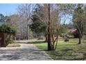 Long, paved driveway leading to the property surrounded by trees at 39058 Nc 740 Hwy, New London, NC 28127