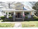 Charming two-story home with a welcoming front porch and beautifully landscaped yard, and patriotic American flag at 421 Mitchell Ave, Salisbury, NC 28144