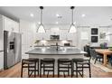 Bright kitchen features a large center island with seating, stainless steel appliances, modern pendant lights, and stylish backsplash at 5231 Hatcher Creek Rd # 44, Charlotte, NC 28215