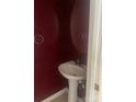 A half bathroom featuring a pedestal sink, mirror, and decorative wall paint at 5650 Kimmerly Woods Dr, Charlotte, NC 28215