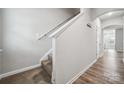 The hallway features neutral walls, wood-look floors, and a staircase with carpeted steps at 10036 Brittondale Ln, Charlotte, NC 28215