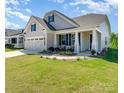 Beautiful home featuring a covered front porch, two-car garage, and landscaped front yard at 10421 Superb Ln, Charlotte, NC 28215