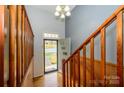 View of front door, wooden stairs, and wood paneling in a naturally lit foyer at 107 Wedgewood Ne Cir, Concord, NC 28025