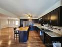 Modern kitchen with dark wood cabinets, stainless appliances, central island and hardwood flooring at 1301 Huckleberry Dr, Lincolnton, NC 28092