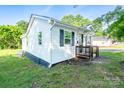 Exterior shot of the home featuring white siding, black shutters, and a quaint front porch at 1413 Caldwell St, Gastonia, NC 28052