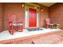 Inviting covered front porch featuring rocking chairs, a bright red door, and classic brick accents at 161 Seven Springs Loop # 11, Statesville, NC 28625