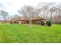 Sprawling front yard of brick home, showcasing mature trees and established landscaping at 161 Seven Springs Loop # 11, Statesville, NC 28625