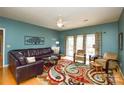 Comfortable living room with hardwood floors, ceiling fan, leather sofa, and access to the backyard at 161 Seven Springs Loop # 11, Statesville, NC 28625