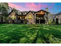 Expansive backyard featuring a brick home, covered patio, and lush green lawn at 1614 Shimron Ln, Waxhaw, NC 28173
