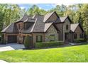 Elegant brick and stone home with a lush green lawn and mature landscaping at 1614 Shimron Ln, Waxhaw, NC 28173