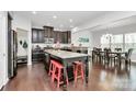 Elegant kitchen featuring granite countertops, dark cabinetry, kitchen island with breakfast bar, and dining area at 1809 Mill Creek Sw Ln, Concord, NC 28025