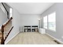 Open living room featuring a staircase, window, storage cabinet, and neutral decor at 1809 Mill Creek Sw Ln, Concord, NC 28025