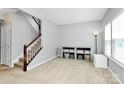 Open-concept living room with staircase, lots of natural light, and neutral walls and flooring at 1809 Mill Creek Sw Ln, Concord, NC 28025