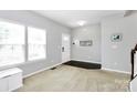Bright living room with a large window, light gray walls, and wood-look entry flooring at 1809 Mill Creek Sw Ln, Concord, NC 28025