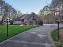Stately home exterior with stone and brickwork, lush lawn and black lamp posts lining the driveway at 1832 Marthas Vineyard Rd, York, SC 29745
