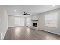 Bright living room featuring a painted brick fireplace, ceiling fan, and large windows for natural light at 1921 Woodridge Dr, Hickory, NC 28602