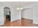Elegant dining room with hardwood floors, archway, chandelier, and wainscoting detail at 1923 Caprington Dr, Fort Mill, SC 29707