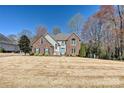 Beautiful two-story brick home with a well-maintained lawn and mature trees on a sunny day at 2901 Barnard Castle Ln, Matthews, NC 28104