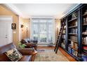 Cozy living room with leather furniture, a built-in bookcase with ladder, and natural light at 4232 Belle Meade Cir, Belmont, NC 28012
