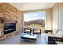 Cozy outdoor patio with brick fireplace, comfortable seating, and serene wooded views at 5045 Grain Orchard Rd # 3027D, Indian Trail, NC 28079