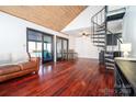 Spacious living room with hardwood floors, spiral staircase, sliding glass doors, and a comfortable sofa at 6199 Timberlane Ter, Hickory, NC 28601