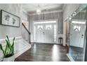 Bright entryway showcasing double doors, hardwood floors, and a staircase with white trim at 6276 Artigas Dr, Fort Mill, SC 29707